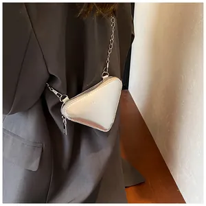 Détail du sac bandoulière triangulaire argenté avec fini métal et chaîne chic