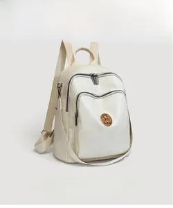 Detail of off-white geometric patchwork backpack featuring vintage copper logo plate