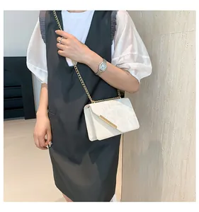 Chic beige crossbody bag with textured relief patterns and elegant gold chain strap detail
