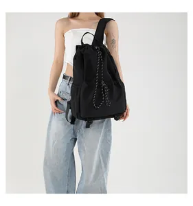 Détail du sac à dos seau en nylon noir avec cordon de serrage et poches latérales