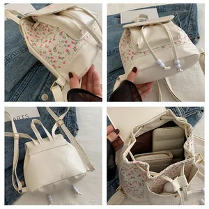 Close-up of cream PU leather backpack with floral patterns and internal storage capacity