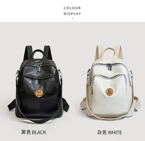 Detail of black and white textured backpacks featuring golden round bear emblem badges