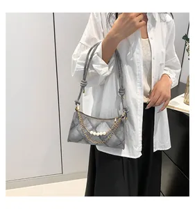 Sac sous le bras matelassé gris chic avec chaîne dorée et perles sur mannequin