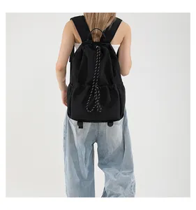 Vue détaillée du sac à dos en nylon noir avec cordon de serrage et bretelles à motifs