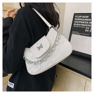 Close-up of white marble pattern shoulder bag with silver butterfly and chain detail