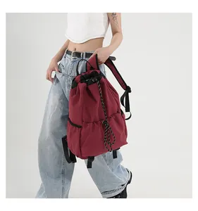 Détail du sac à dos en nylon bordeaux avec cordon de serrage et poche latérale sur le mannequin