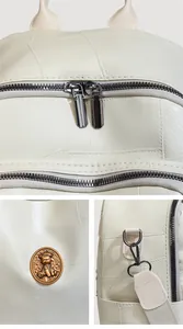 Detail view of lychee-textured leather backpack with bear crest and metal zippers