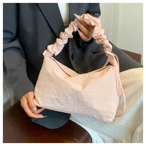 Nahaufnahme der hellrosa Plissee-Stofftasche mit gerafftem Griff und Knitter-Textur