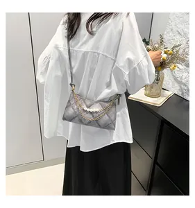 Détail du sac matelassé gris avec chaîne dorée et accents élégants de bandoulière perles