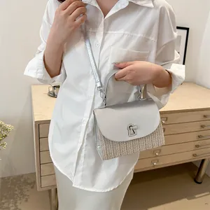 Silver leather and straw tote bag with metallic lock shown in a casual lifestyle setting