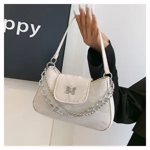Detail of off-white marble print handbag featuring butterfly clasp and double metal chains