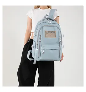 Detail showing the light blue fashion backpack with multiple zipper pockets on model
