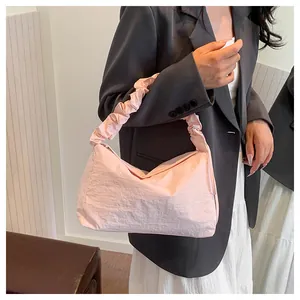 Rosa Schultertasche aus Segeltuch mit gerafftem Griff an einem Modell getragen