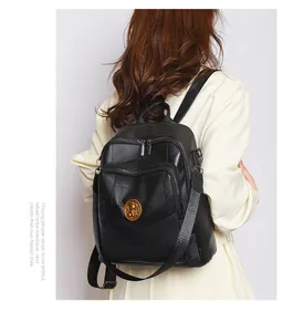 Detail of black leather backpack featuring geometric patterns and golden relief logo