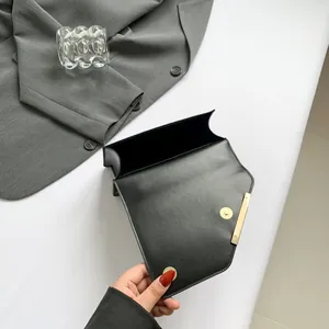 Fashion black square flap shoulder bag with gold metal edge and chain strap on white surface