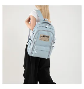 Detail of light blue nylon backpack with FASHION patch, zippers and side buckle
