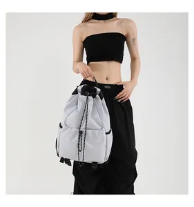 Détail du sac à dos gris en nylon avec cordon de serrage et poche élastique avant
