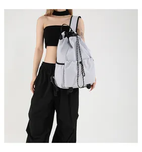 Détail d'un grand sac à dos en nylon gris clair avec cordon et boucles réglables