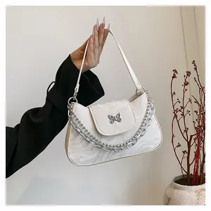 Detail of white marble-patterned bag featuring a silver butterfly buckle and metal chain