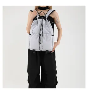 Vue détaillée du sac à dos en nylon gris clair avec cordon et poches latérales