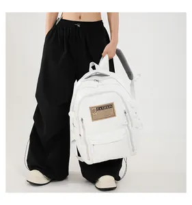 Detail view of white PU leather backpack featuring multiple zippers and vintage fashion label
