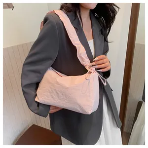 Detail der rosa Canvas-Tasche mit gefaltetem Schultergurt und Schleifenverzierung