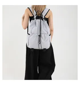 Détail d'un sac à dos en nylon gris clair avec cordon de serrage et sangles noires