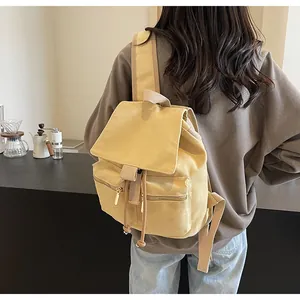 Vista posterior de una mochila tipo cubo de lona jengibre con cordón y bolsillos con cremallera