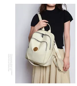 Close-up of cream PU leather backpack featuring zipper pockets and metallic hardware detail