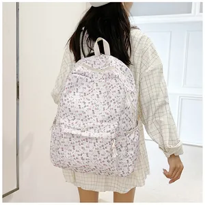 Détail du sac à dos fleuri sur un mannequin avec imprimé lavande et texture toile