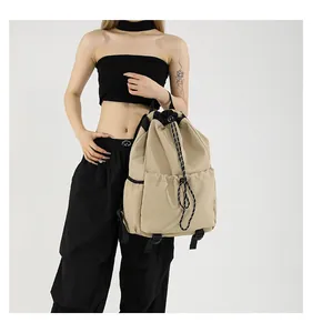 Détail du sac à dos en nylon kaki avec cordon de serrage et boucles noires robustes