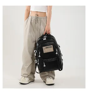 Detail view of black PU leather backpack with silver zippers and fashion cloth label