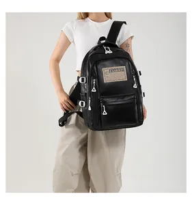 Detail shot of the black soft PU leather backpack featuring industrial fashion labels