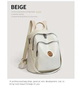 Close-up of beige travel backpack featuring pebbled texture and dual front zippers