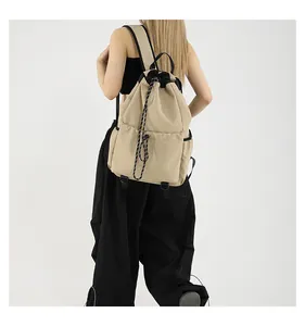 Vue détaillée du dos d'un grand sac à dos en nylon beige avec des détails noirs chic