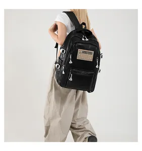 Detail view of black PU leather backpack with multi-zipper pockets and fashion fabric label