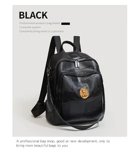 Close-up of black textured faux leather backpack with metallic emblem and zipper detail
