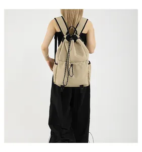 Détail d'un sac à dos en nylon kaki avec cordon de serrage et poches latérales noires