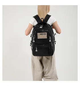 Detail view of black PU leather backpack with vintage label and white buckles on shoulder straps