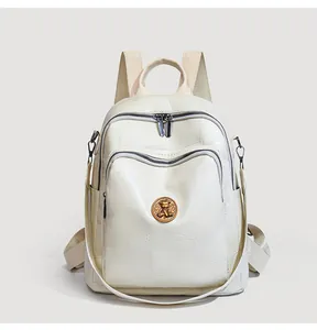 Close-up of litchi grain faux leather backpack with vintage bear badge and zipper detail