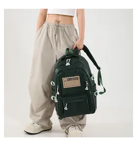 Detail view of dark green waterproof PU backpack featuring fashion label and triangle zippers