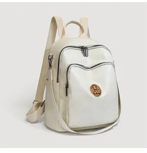 Detail view of large capacity beige leather backpack with quilted pattern and dual zippers