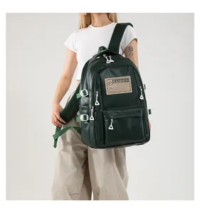 Detail view of dark green PU leather backpack featuring fashion logo and triangle zippers