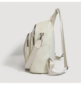 Detail of beige travel backpack featuring geometric embossed texture and side pockets
