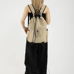 Sac à dos à cordon en nylon kaki avec poches multiples porté par un mannequin