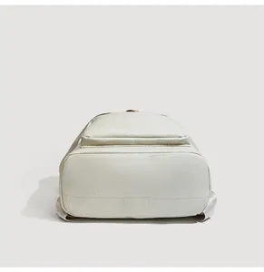 Detailed base view of ivory leather backpack showing durable stitching and patchwork design