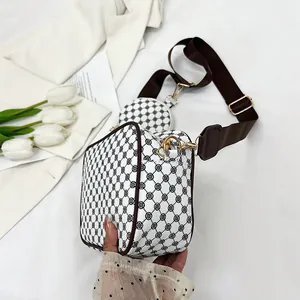 Detail of white monogram crossbody bag set with clover pattern and wide strap