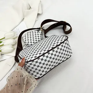 Detail of retro patterned crossbody bag with wide strap and detachable coin purse accessory