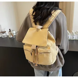 Vista trasera de una mochila de lona amarillo jengibre usada por una modelo en un café