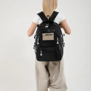 Large black PU leather backpack with fashion labels and white zippers shown on model